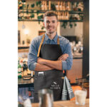 Waist,Up,Of,A,Friendly,Young,Barista,Wearing,An,Apron